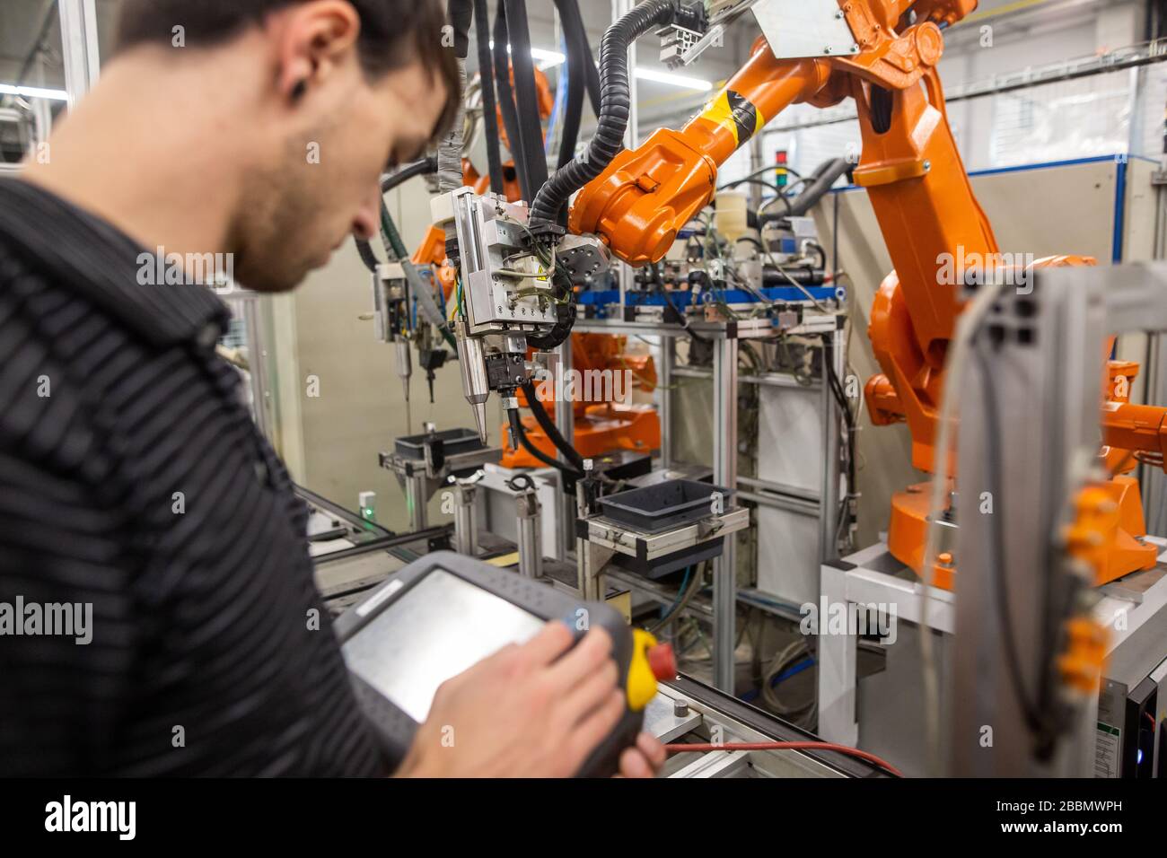 Man programming robot in automotive industrial, professional programmer