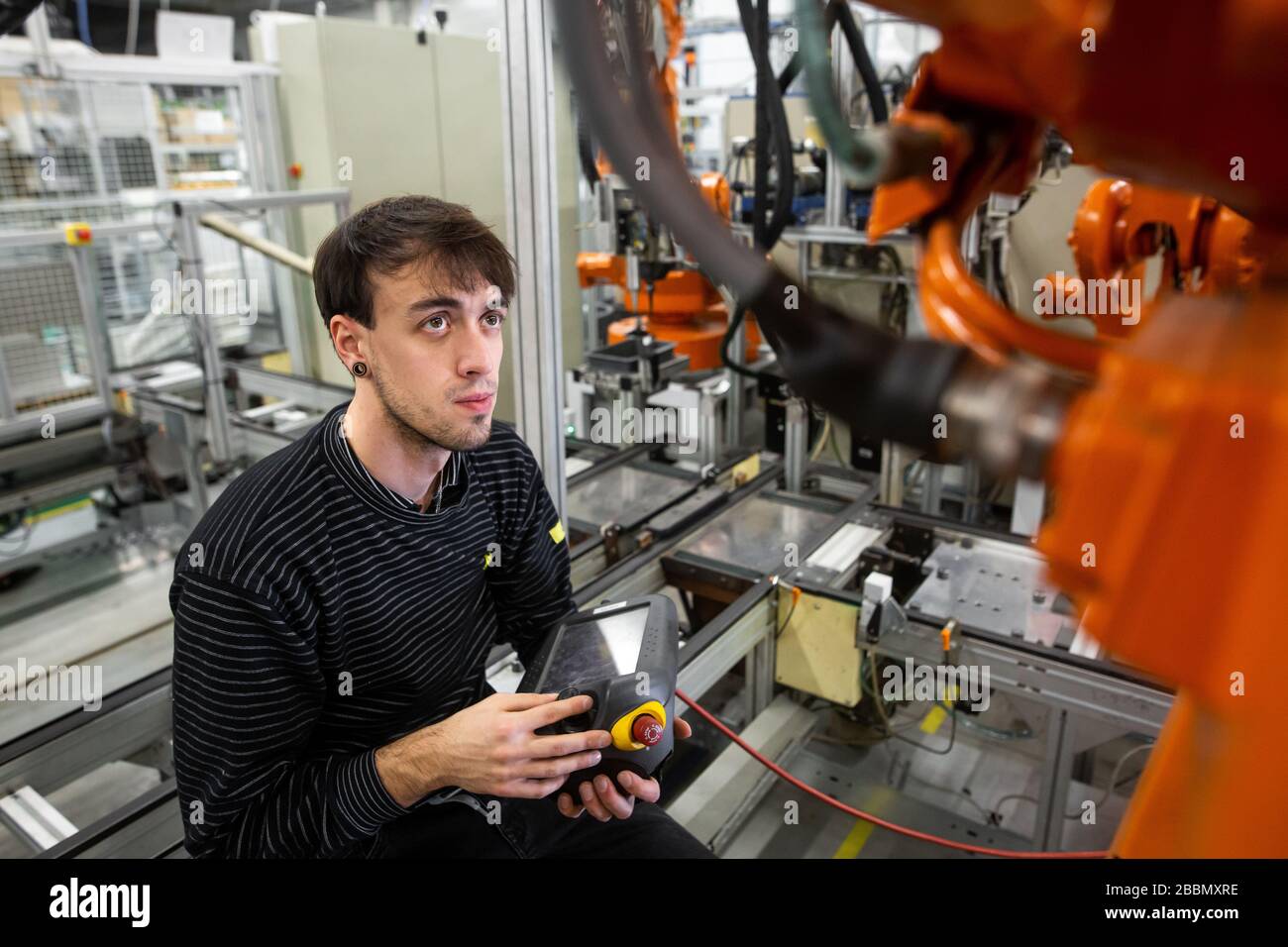 Man programming robot in automotive industrial, professional programmer ...