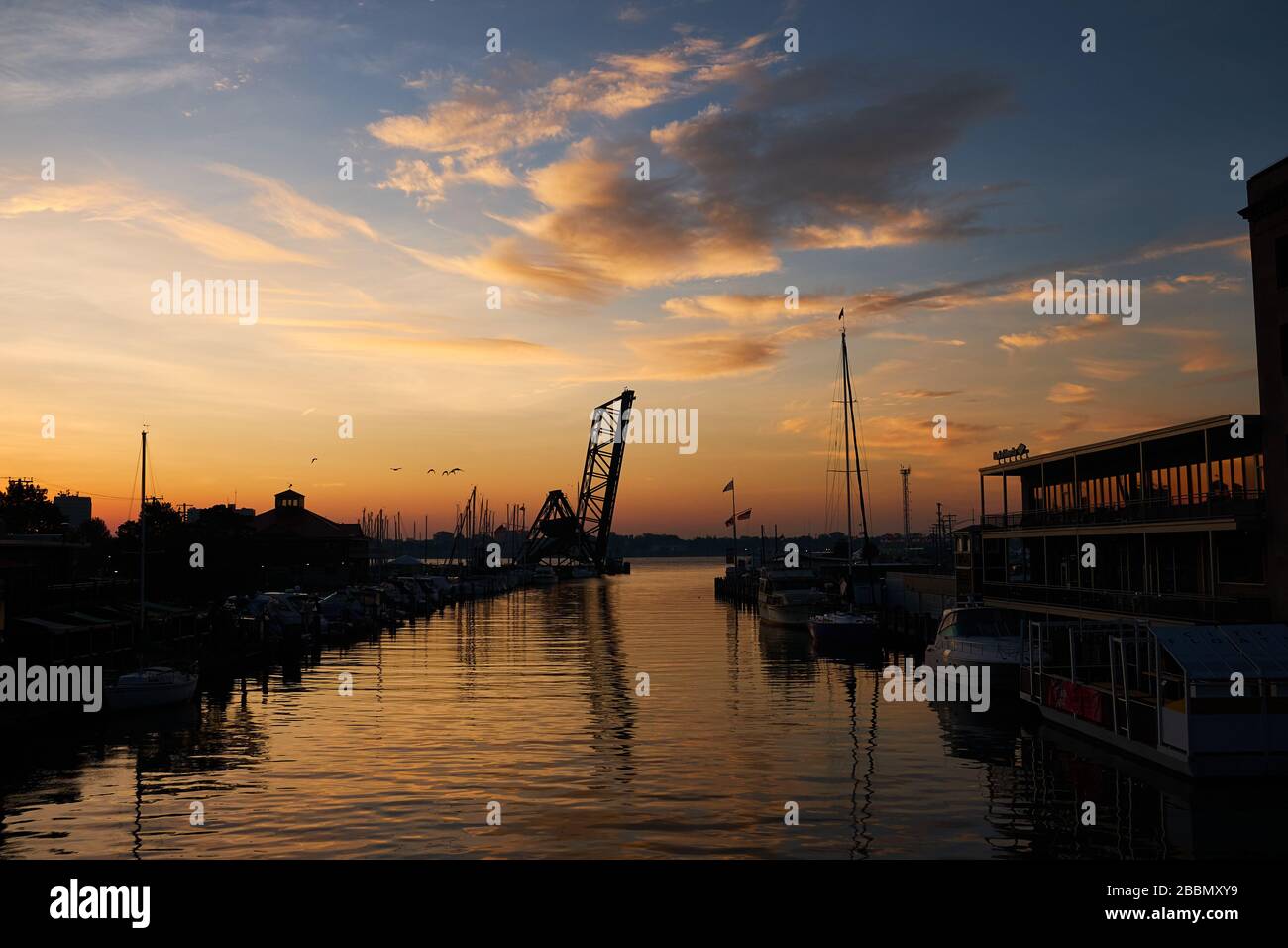 Beautiful sunrise over the Black River downtown Port huron, Michigan with view of city marina and train bridge. Stock Photo