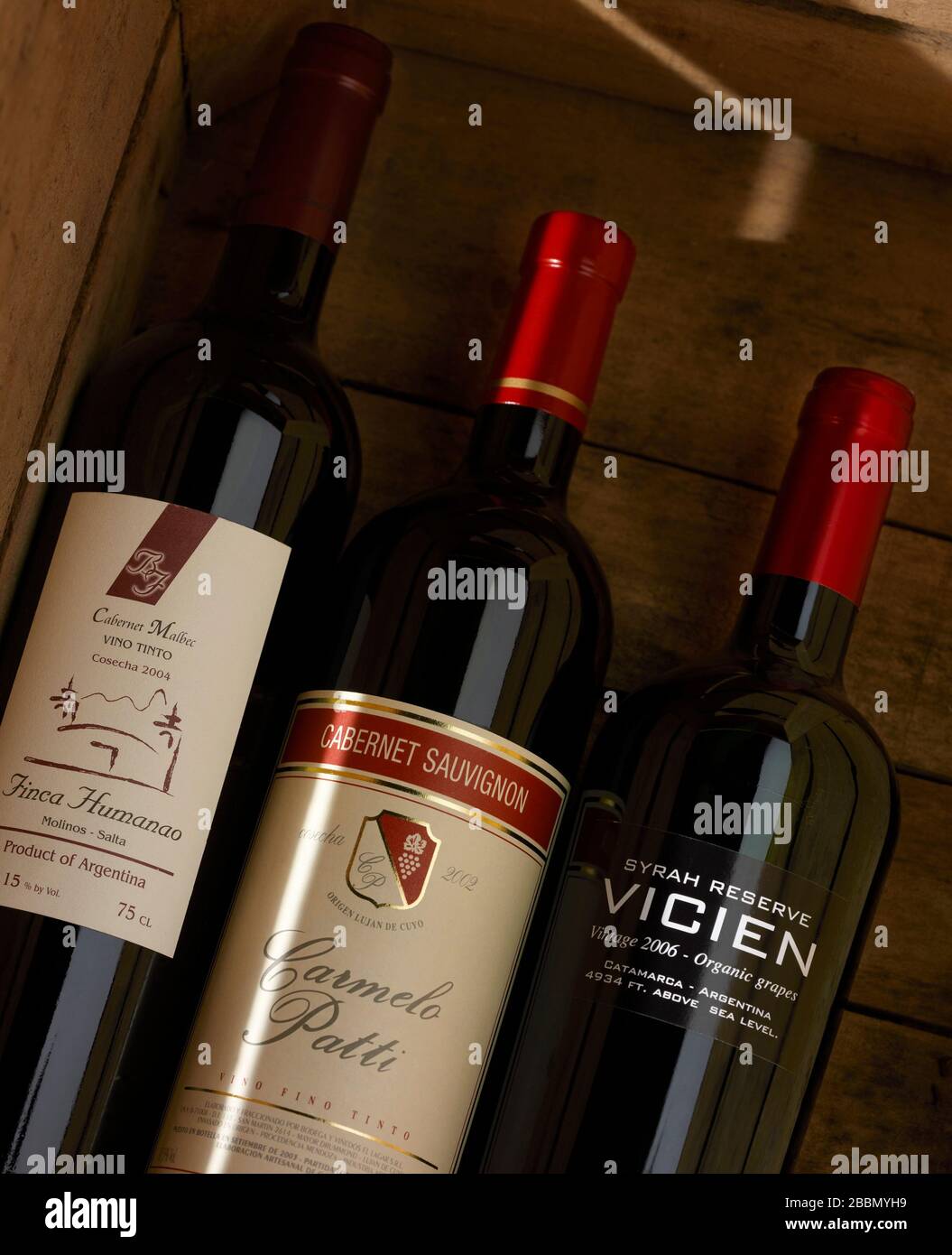 Three red wine bottles in a wooden case Stock Photo