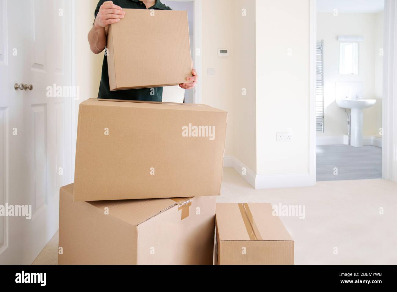 Close Up Of Removal Man Carrying Boxes Into New Home On Moving Day Stock Photo