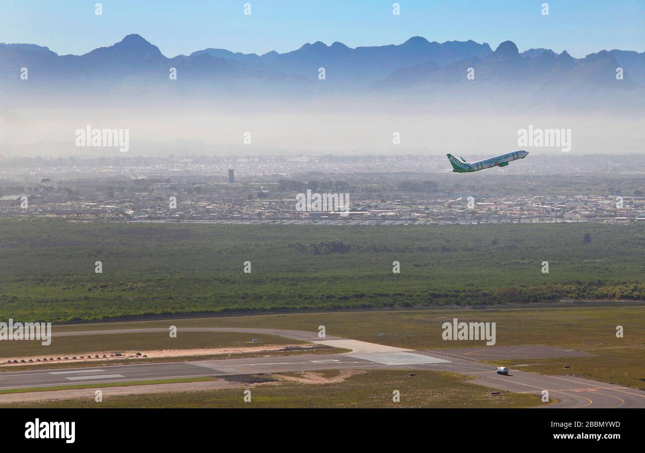 Air to air image of Kulula taking off from Cape Town International Airport with townships in the background Stock Photo