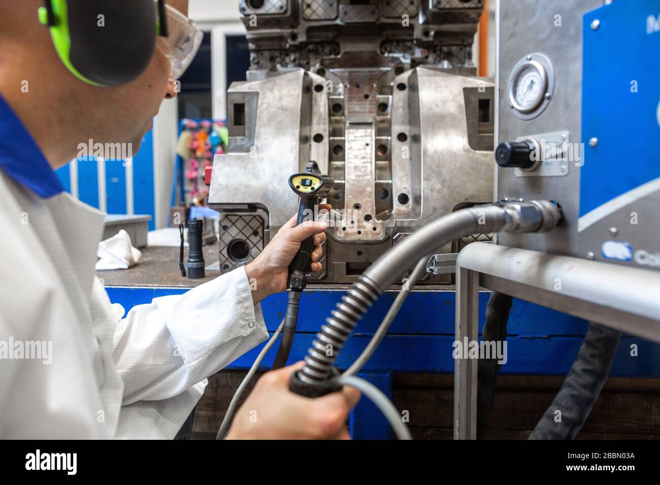 Engineer doing maintenance on a injection mold for plastic components, industrial and automotive concept Stock Photo