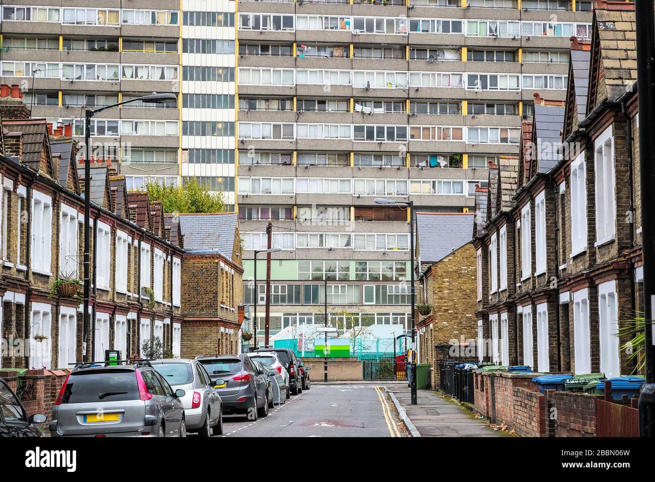 Traditional English terraced houses with huge council block Taplow House, Aylesbury Estate in the background in south east London Stock Photo