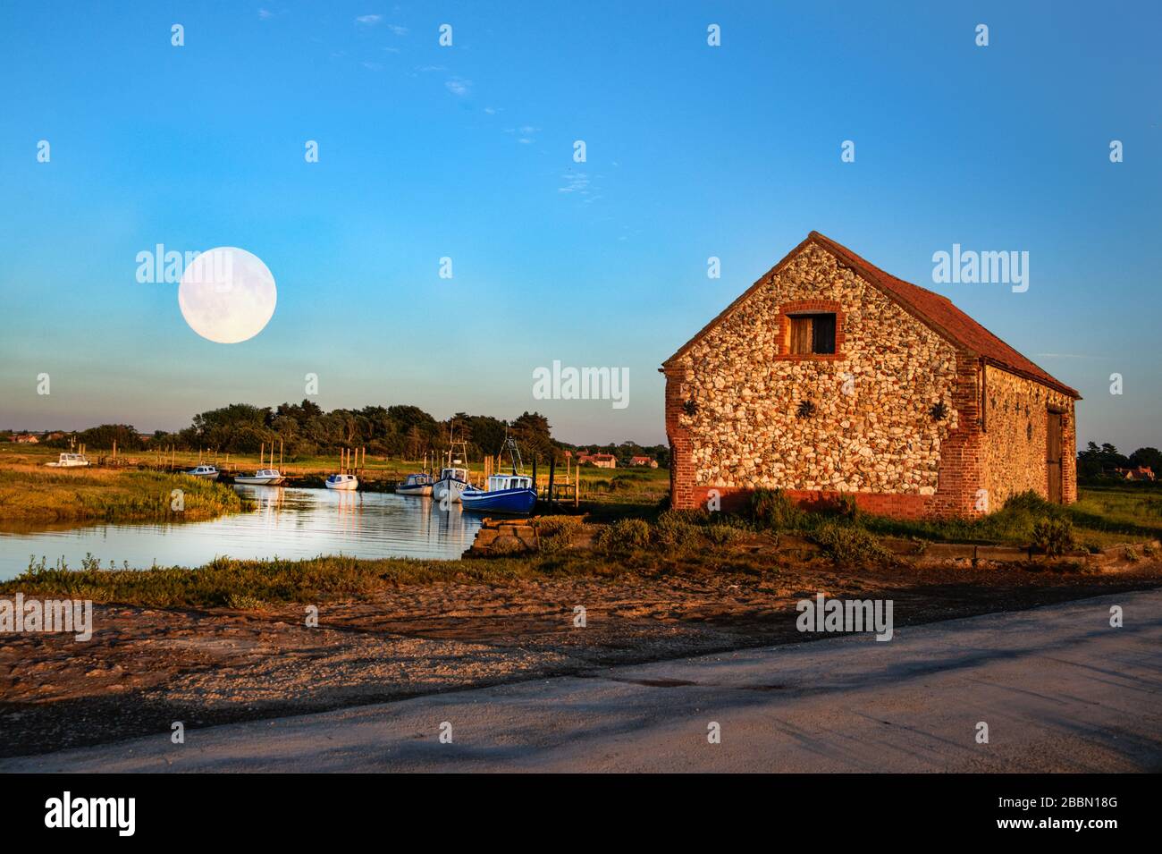 Moon rising over boat house in Thornham, Norfolk, England Stock Photo