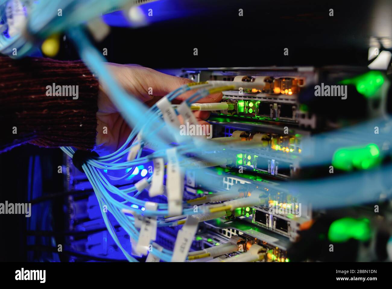 Man data center technician performing server maintenance. Replacing cables, Stock Photo
