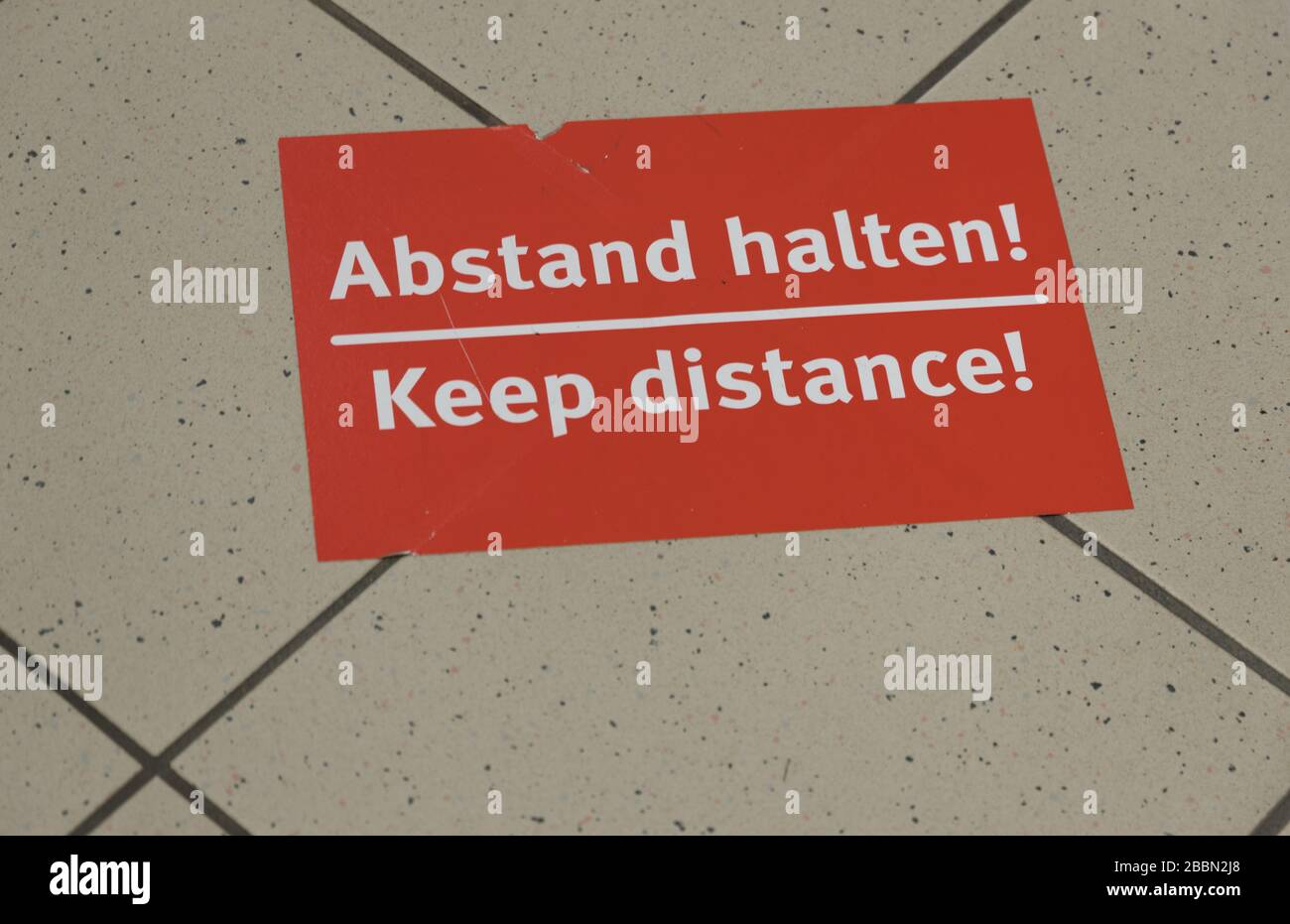 information sign: Keep distance and the german translation: Abstand halten Stock Photo
