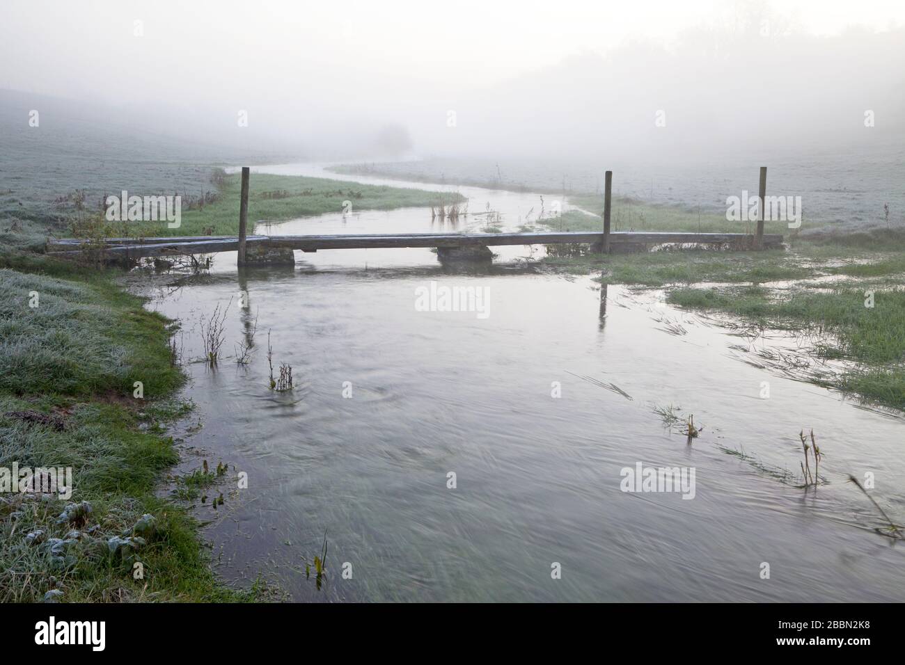 A footbridge on the River Ebble in the village of Fifield Bavant in Wiltshire. Stock Photo