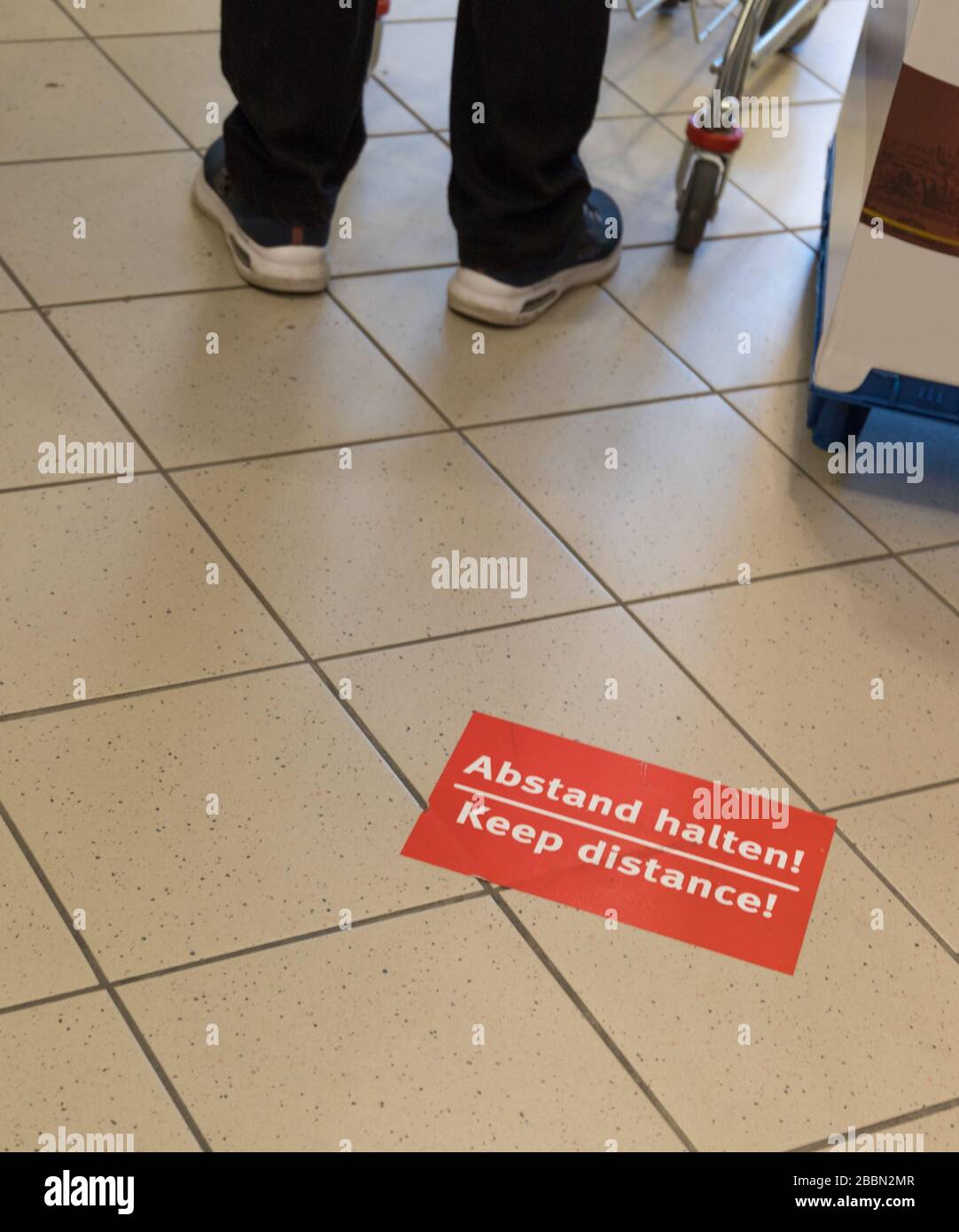 information sign: Keep distance and the german translation: Abstand halten Stock Photo