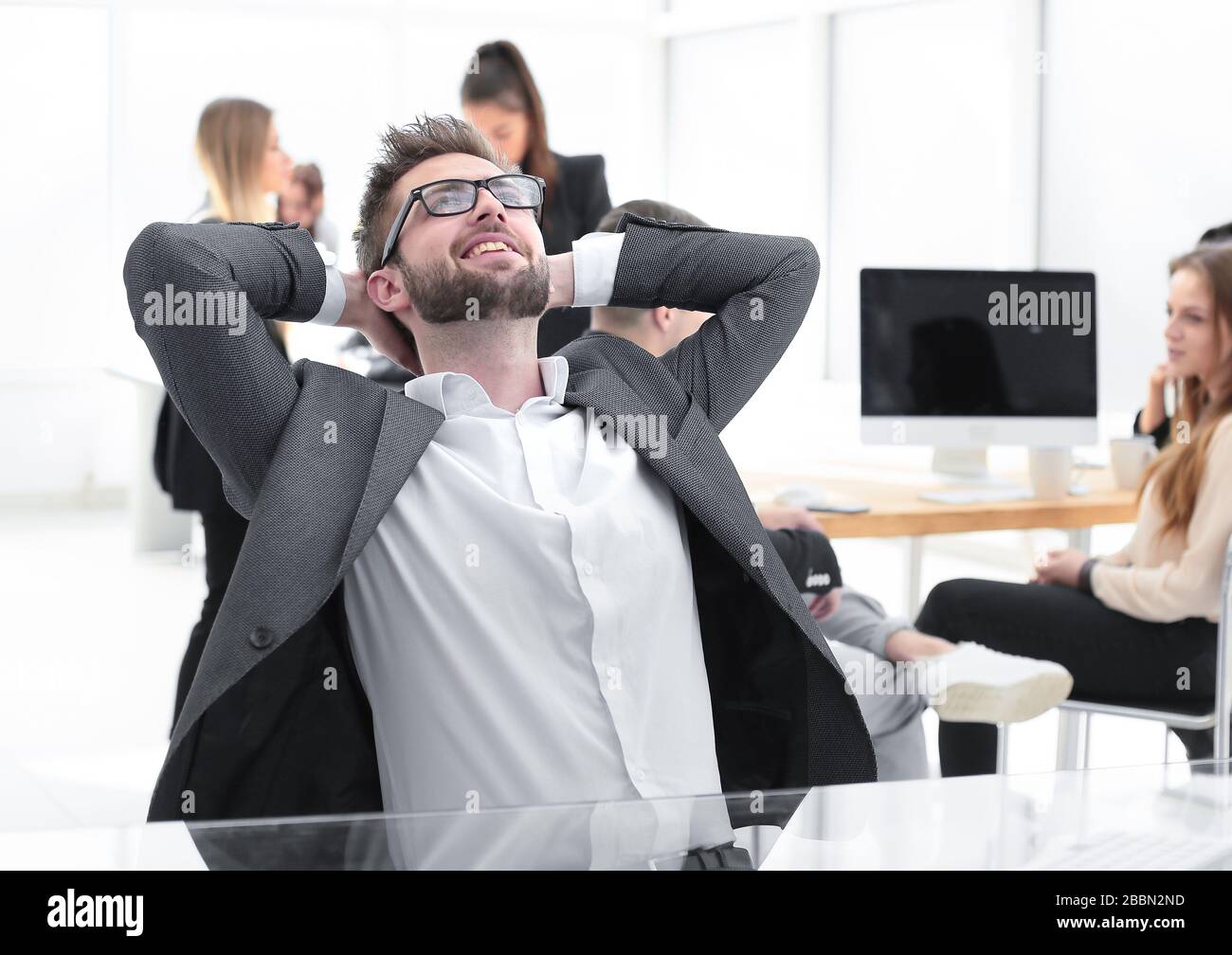 brooding young businessman sitting at an office Desk Stock Photo