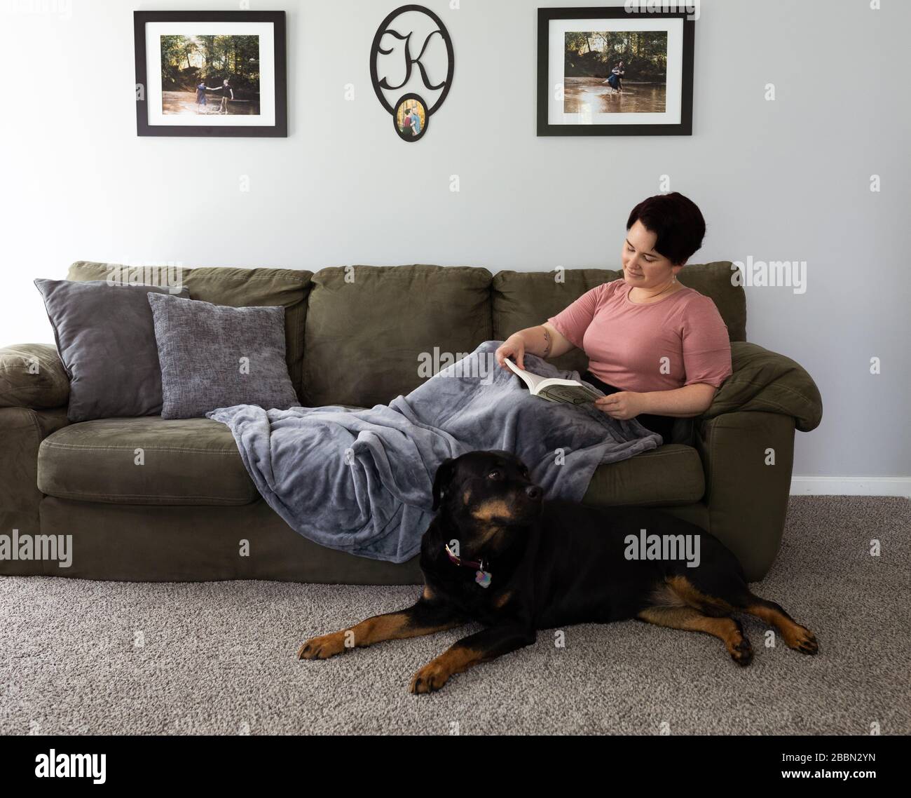 reading at home with rottweiler Stock Photo