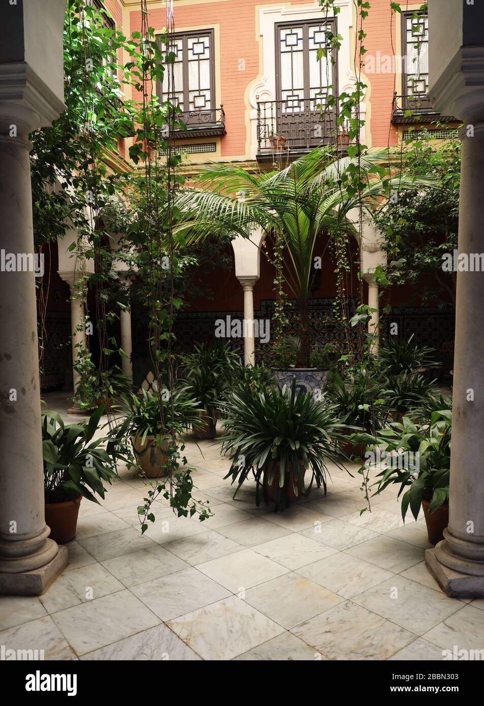 Traditional attractive, tranquil  courtyard with windows. balconies, plants.Spanish street scene.Feel good. Full frame. Seville, Andalucia, Spain Stock Photo