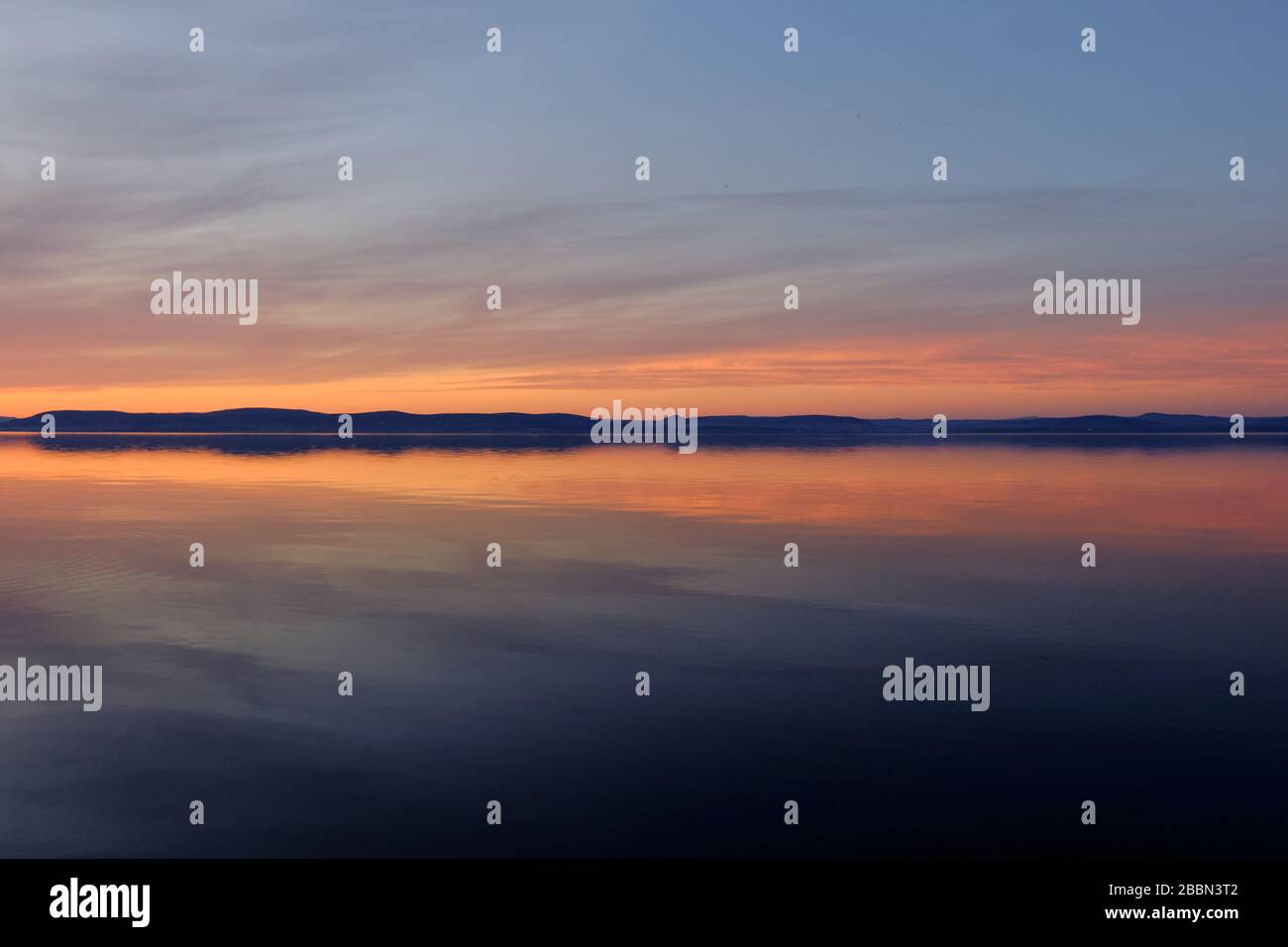 reflecting water distant hills at sunset at lake Balaton, Hungary Stock Photo