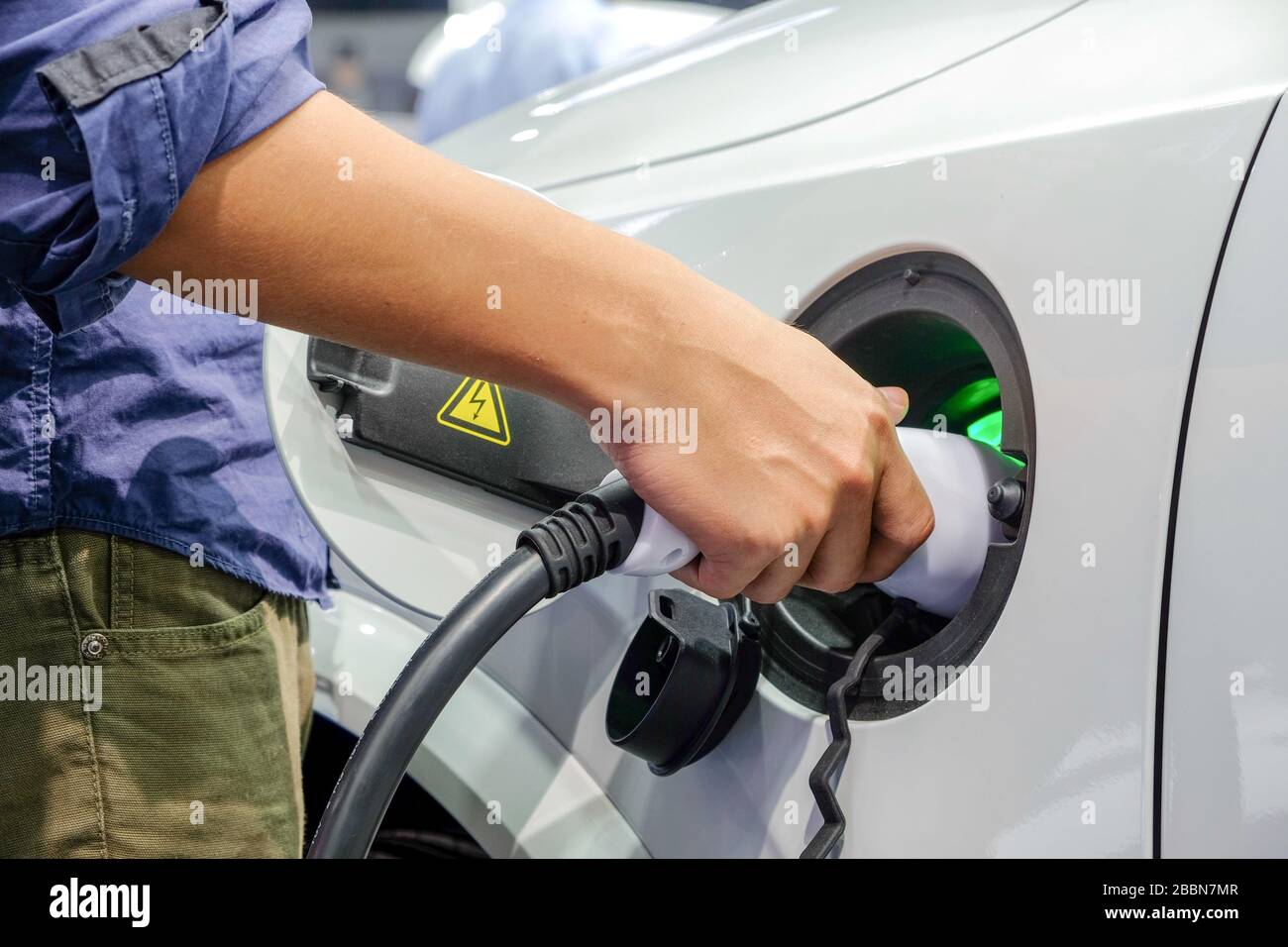 Close-up asia men hands who are fueling a new vehicle electrification via rechargeable electricity machine Stock Photo