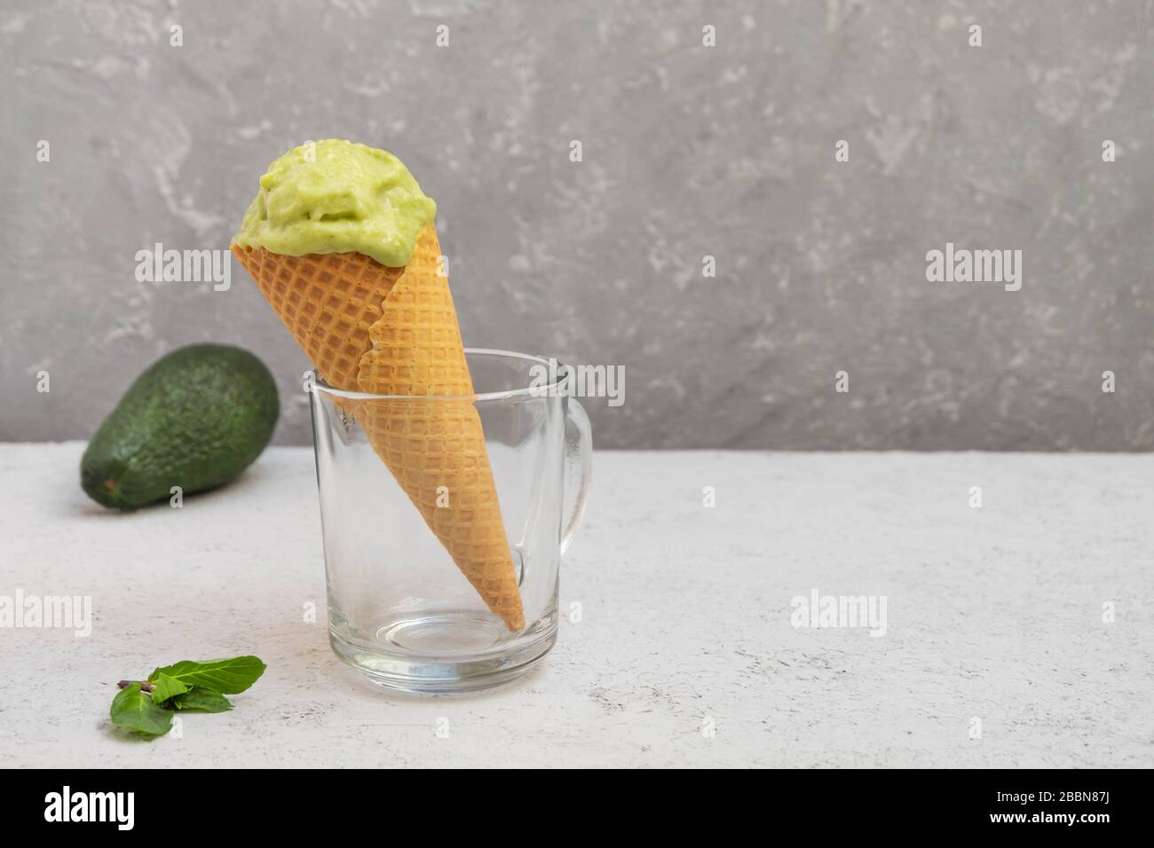 Healthy organic avocado green ice cream in a waffle cone and neutral