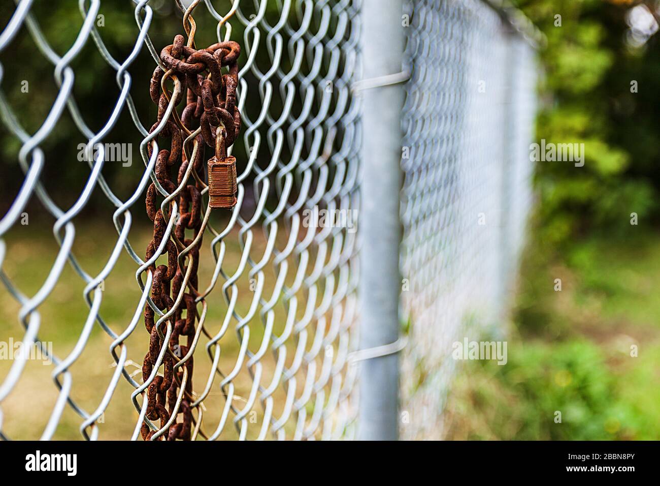 Old rusty padlock attached to a chain on a fence Stock Photo - Alamy