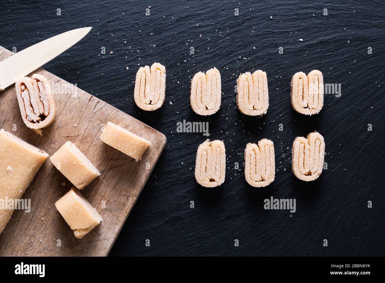 Food concept Homemade raw organic Puff Pastry dough for French Palmiers, Chinese butterfly pastries or elephant ears pastry on black slate board Stock Photo