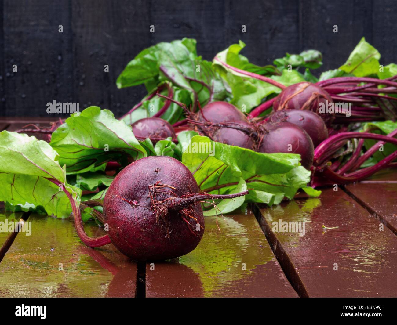Close-up of organic beetroots with leaves on wooden table Stock Photo