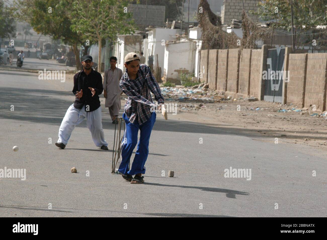 Boys playing cricket on the street in Karachi Stock Photo