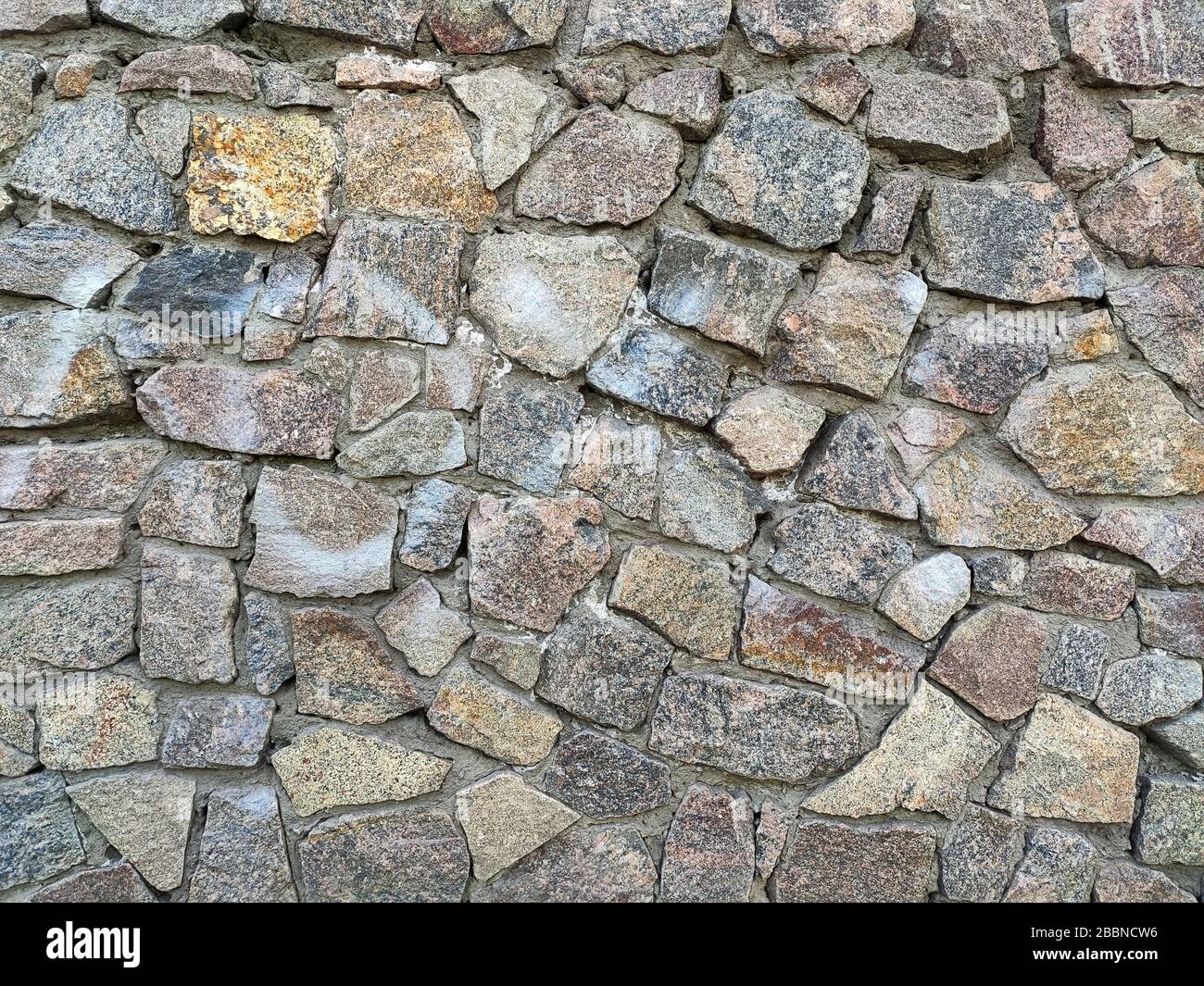 Background of large stones wall texture with different colors stones Stock Photo