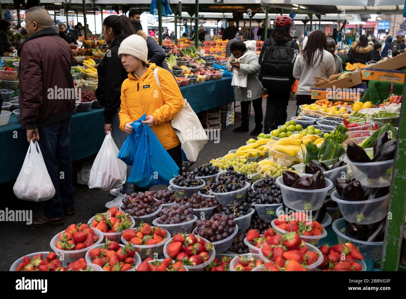 People out shopping in Bullring Open Market, an outdoor food, fruit and vegetable market in central Birmingham on 14th March 2020 in Birmingham, United Kingdom. The Open Market offers a huge variety of fresh fruit and vegetables, fabrics, household items and seasonal goods. The Bull Ring Open Market has 130 stalls. Stock Photo