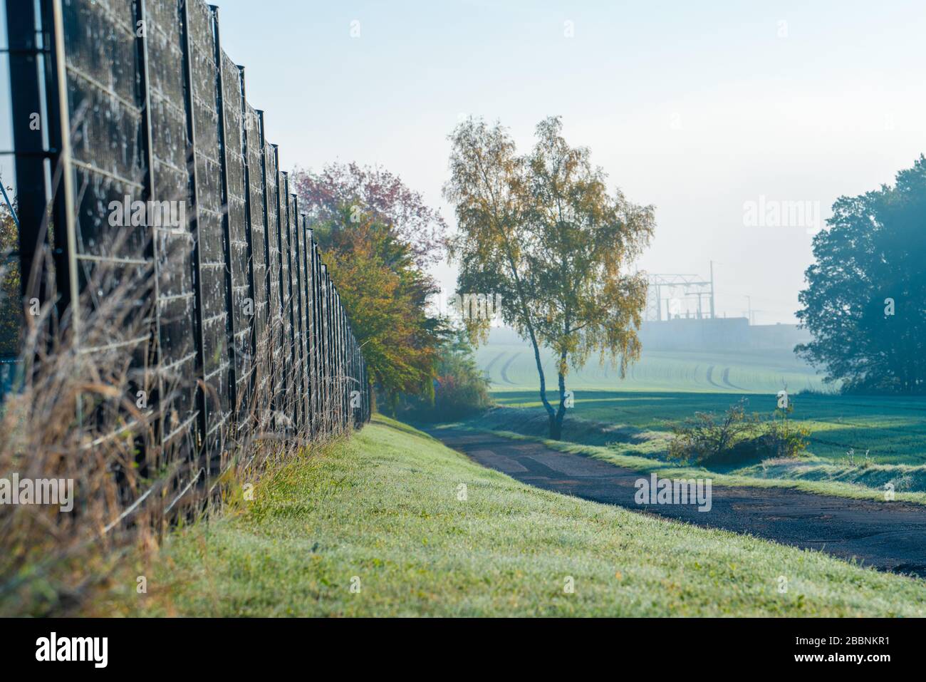 Metal fence of private area with grass around Stock Photo - Alamy