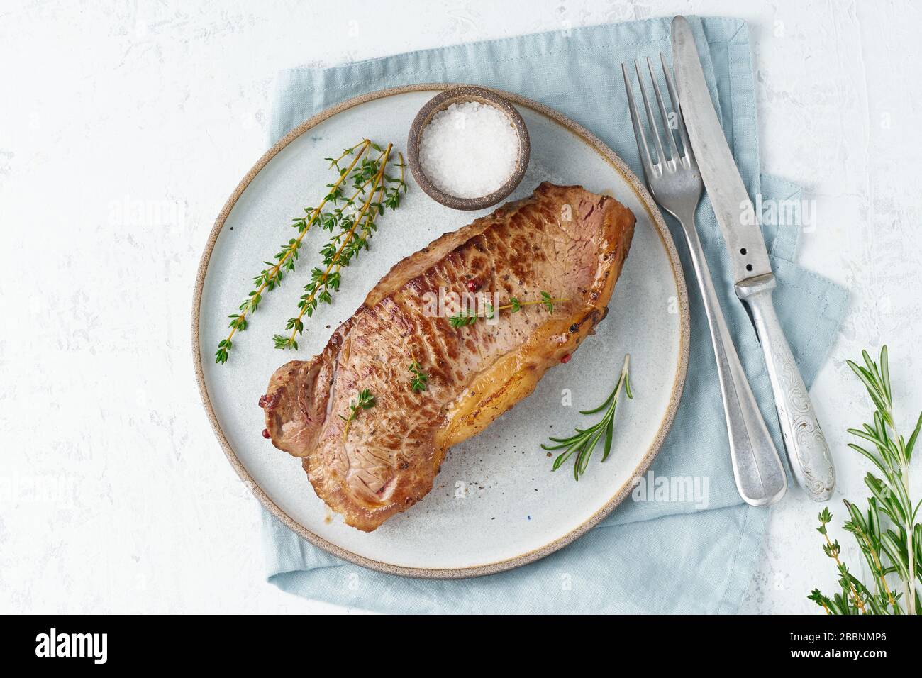 Keto ketogenic diet beef steak, striploin on gray plate on white