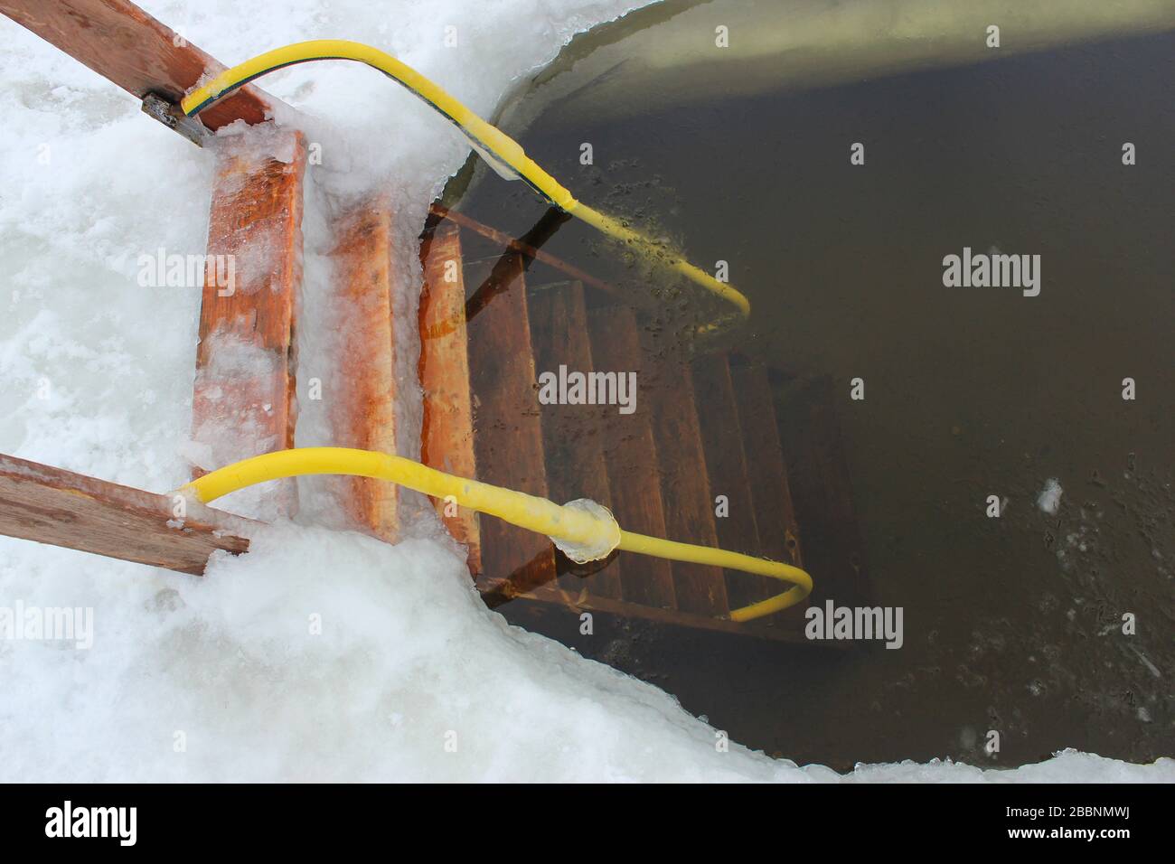 Epiphany ice hole on the Volga in winter, equipped with a ladder for launching into the water Stock Photo