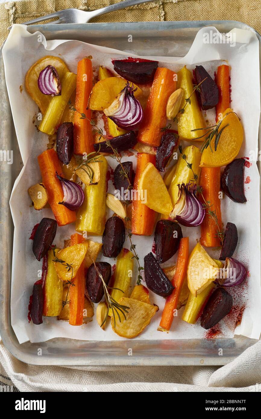 Colorful roasted vegetables on tray with parchment. Mix of carrots