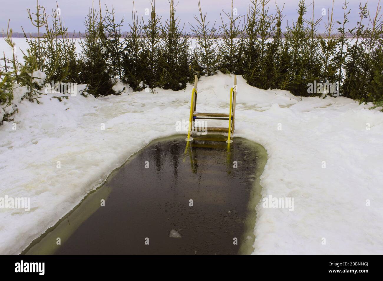 Epiphany ice hole on the Volga in winter, equipped with a ladder for launching into the water Stock Photo