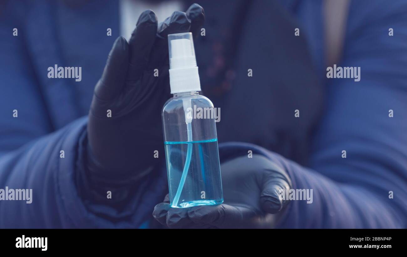 Close-up of young person holding in the hand antiseptic or anti bacteria spray. Disinfecting hands. Concept of health care during an epidemic or pande Stock Photo
