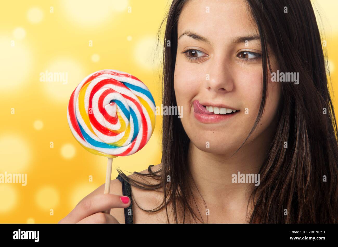 Pretty brunette teenager eager for her big and sweet lollipop Stock Photo