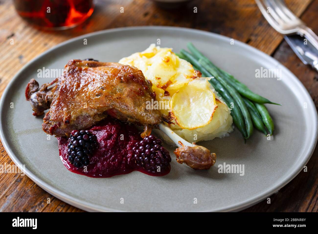 Roast duck leg with beetroot and blackberry puree and dauphinois potatoes Stock Photo