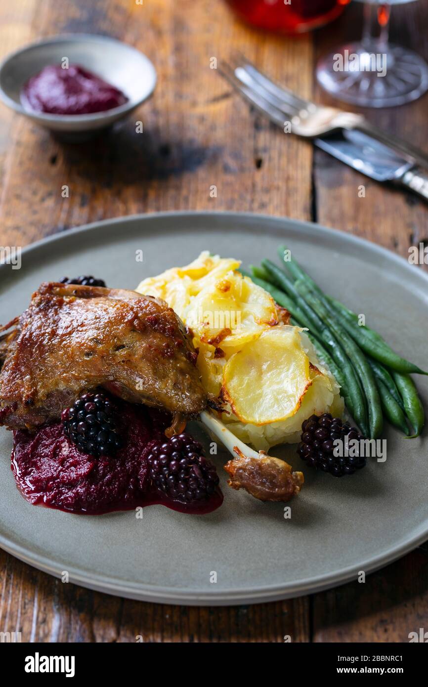 Roast duck leg with beetroot and blackberry puree and dauphinois potatoes Stock Photo