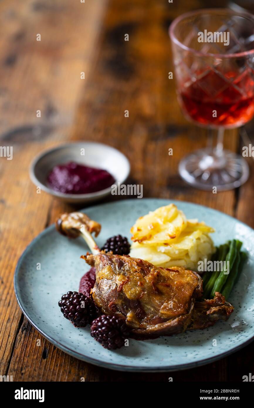 Roast duck leg with beetroot and blackberry puree and dauphinois potatoes Stock Photo