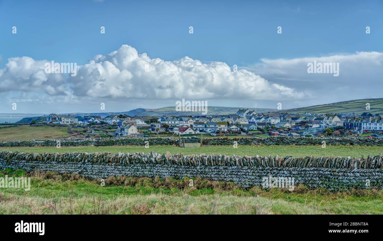 A beautiful clear winters day looking across green fields surrounded by herringbone stone walls at the edge of Tintagel Village in Cornwall, England. Stock Photo