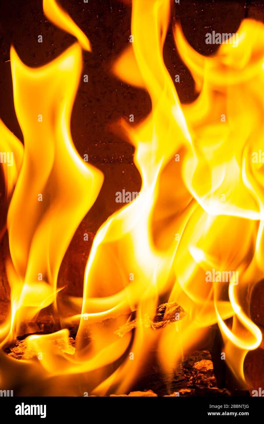 Close up on flamme burning in the fireplace during a cold winter night Stock Photo