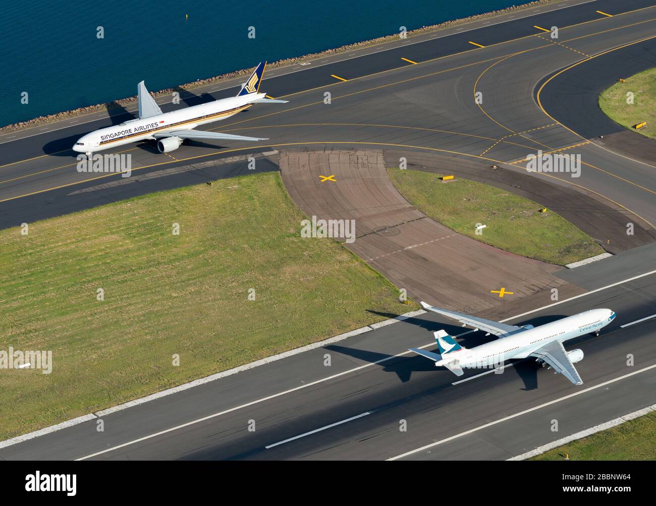 Cathay Pacific Airbus A330 and Singapore Airlines Boeing 777 at Sydney International Airport in Australia. Airport operations in runway and taxiway. Stock Photo