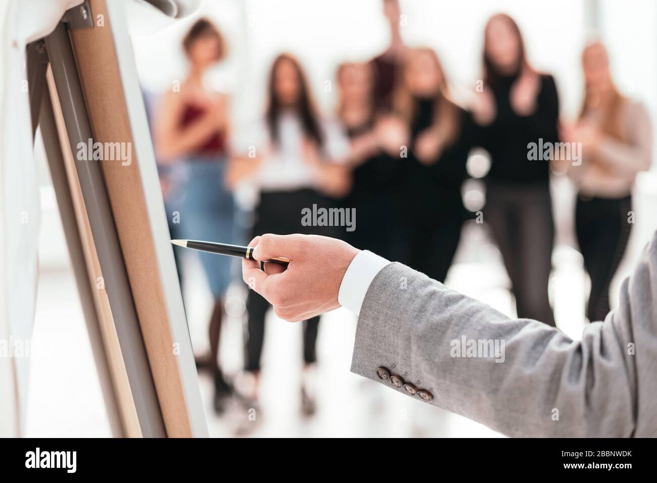 rear view . business man pointing with pen on a flipchart. Stock Photo