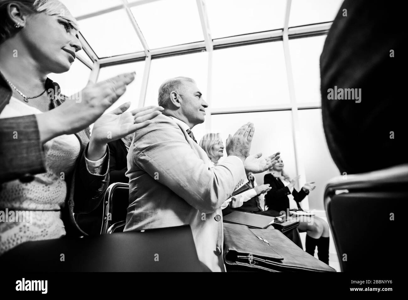side view. smiling business seminar listeners applauding together. Stock Photo