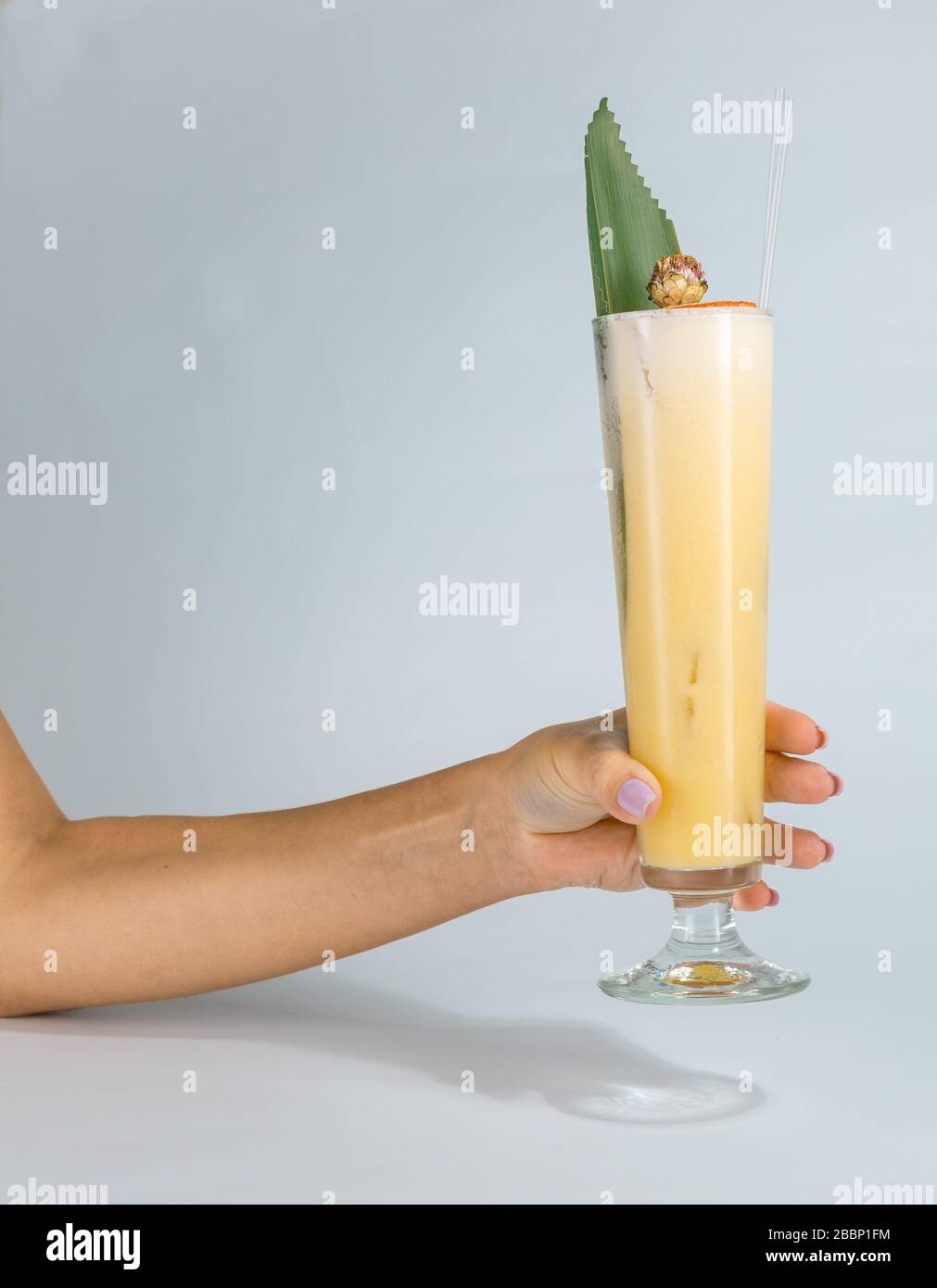 Close Up Of A Womans Hand Holding A Glass Of Tropical Pina Colada Cocktail On White Background 5619