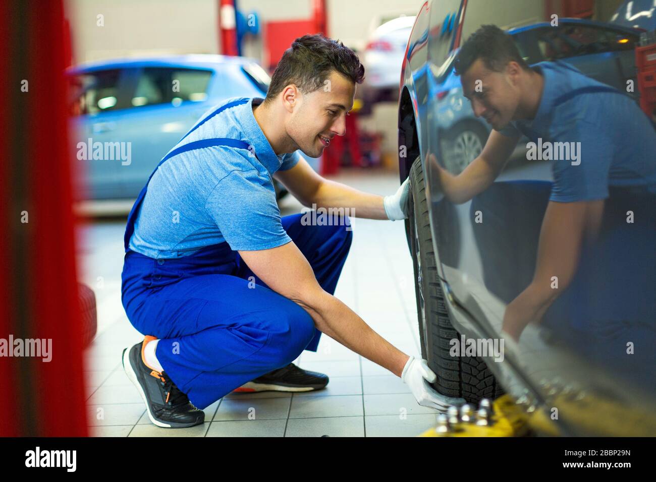 Mechanic working in auto repair shop Stock Photo - Alamy