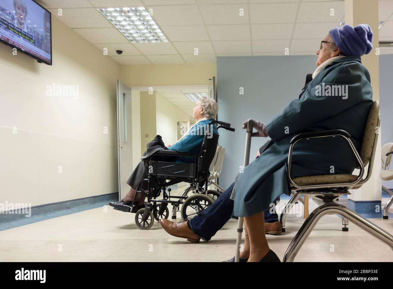 Elderly women watching TV in outpatient clinic waiting room in NHS hospital. UK Stock Photo