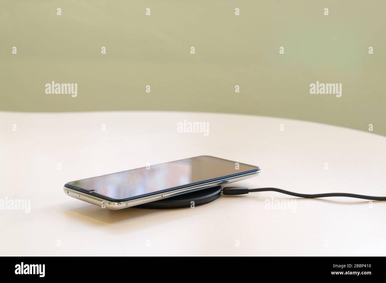 smartphone wireless charging on induction charger. Wireless charger Stock Photo