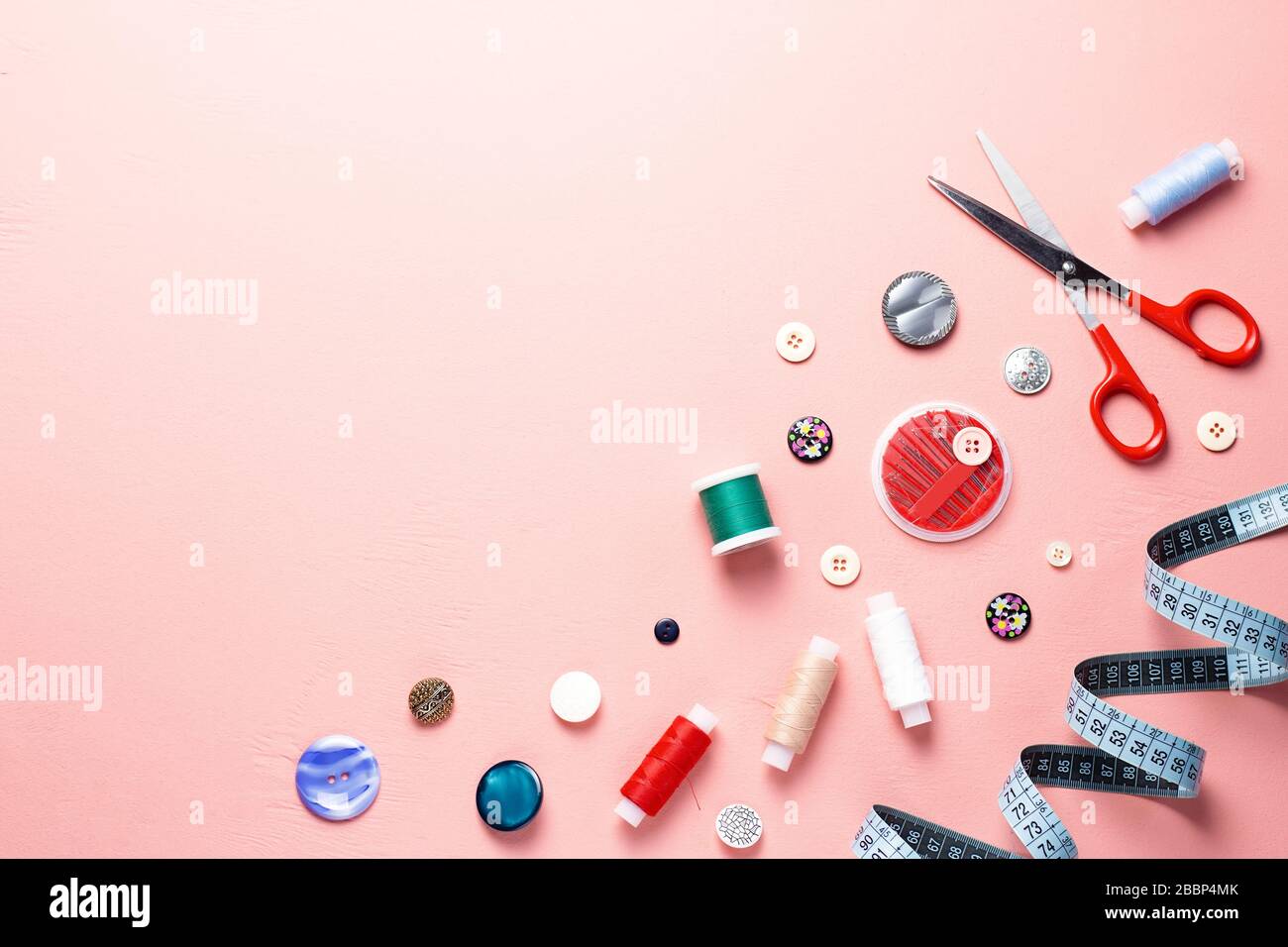 Sewing tools and accessories layout on pink background, top view Stock Photo