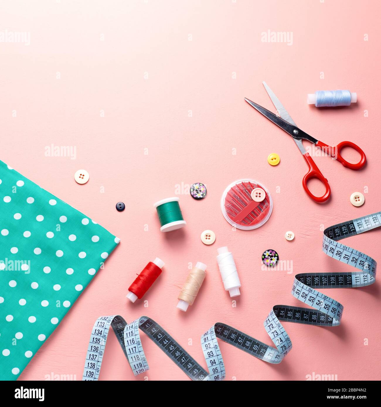 Sewing tools and accessories layout on pink background, top view Stock