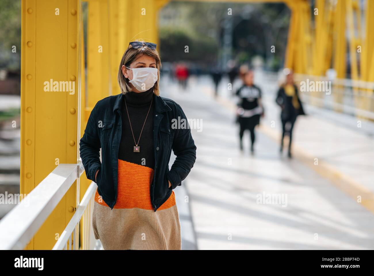 A reckless young Woman walk on crowded street with a mask in a quarantine period because of pandemic global danger Stock Photo