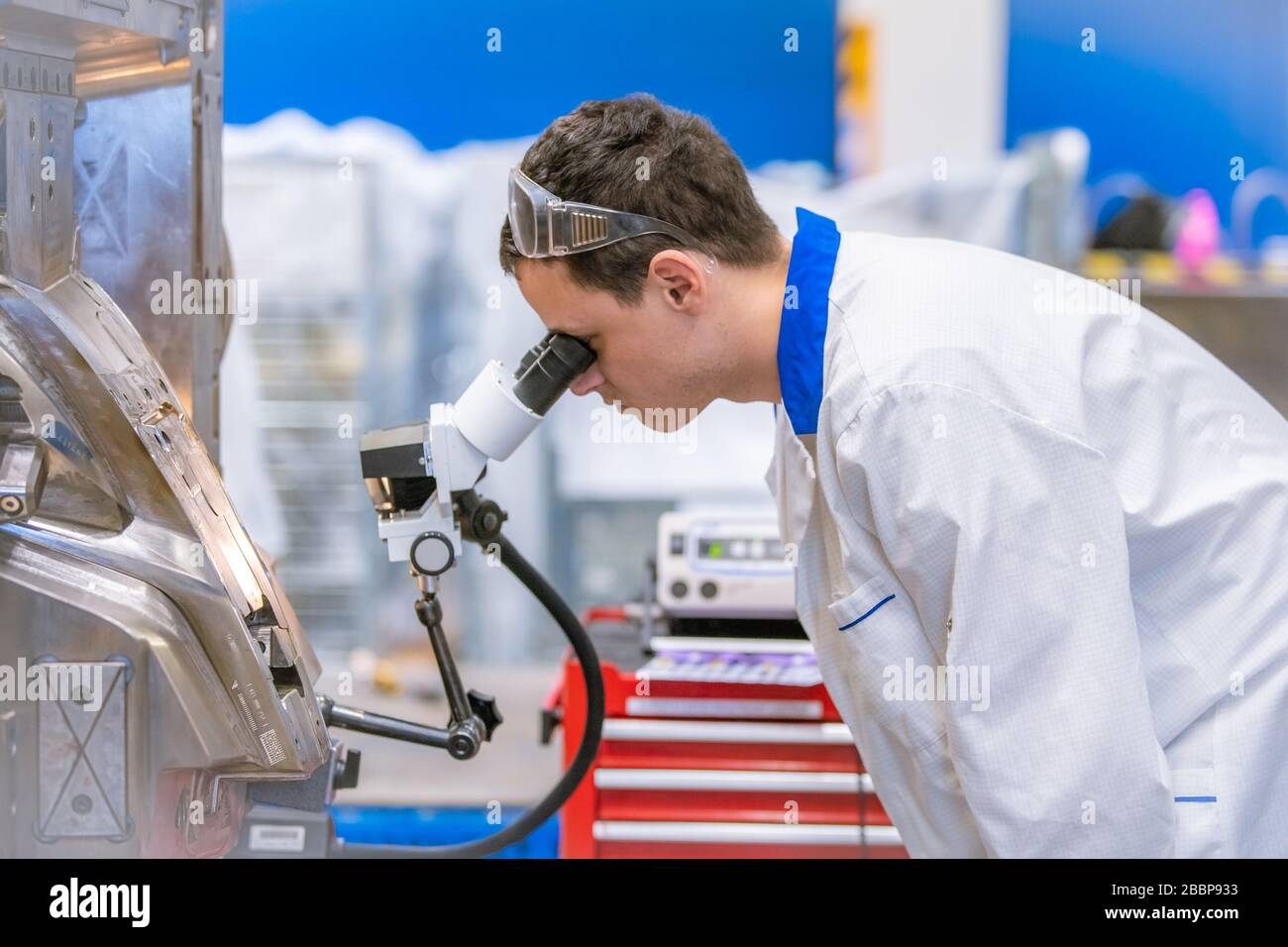 using a microscope while working in a research center Stock Photo