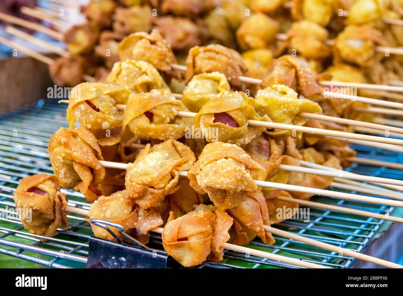 Traditional thai deep fried wanton sausages on a skewer Stock Photo