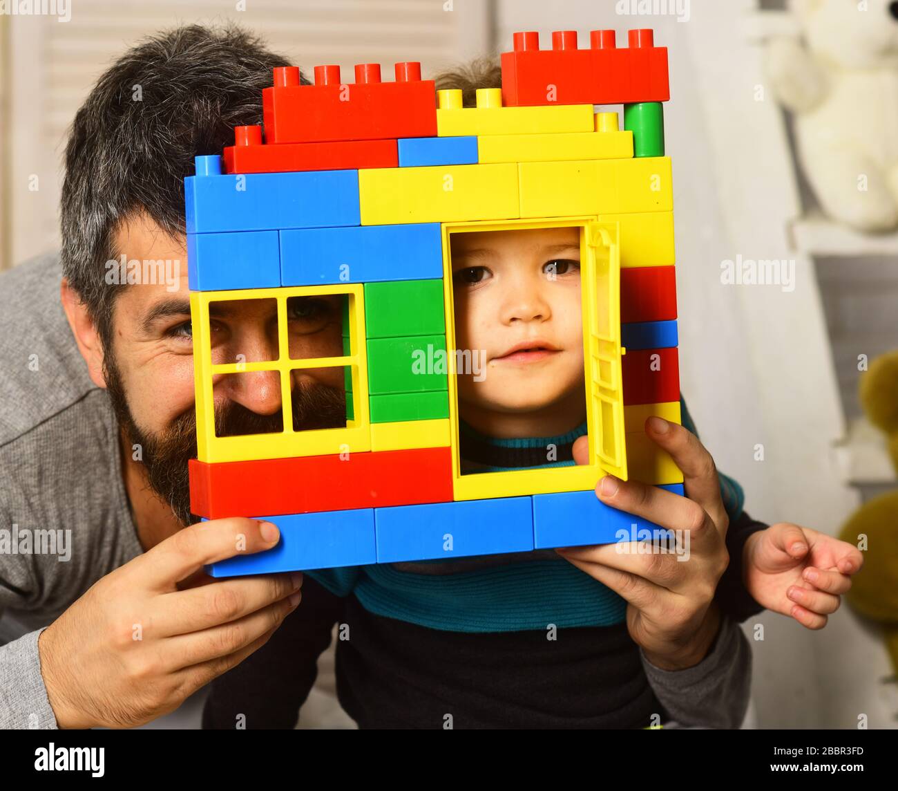 Family day and childhood concept. Dad and kid hide behind building wall